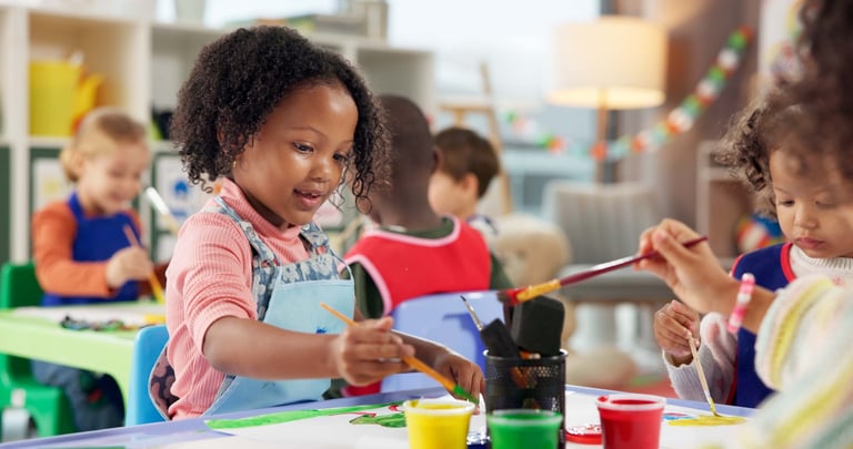Kids in painting class creating art, developing creative talent and motor skills in a bright studio