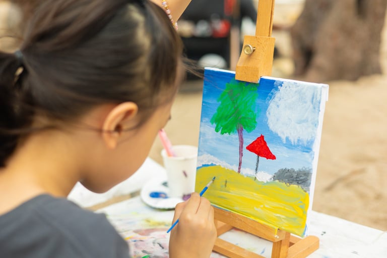 Young girl painting with beautiful colors on canvas showing child's artistic hobby and creativity